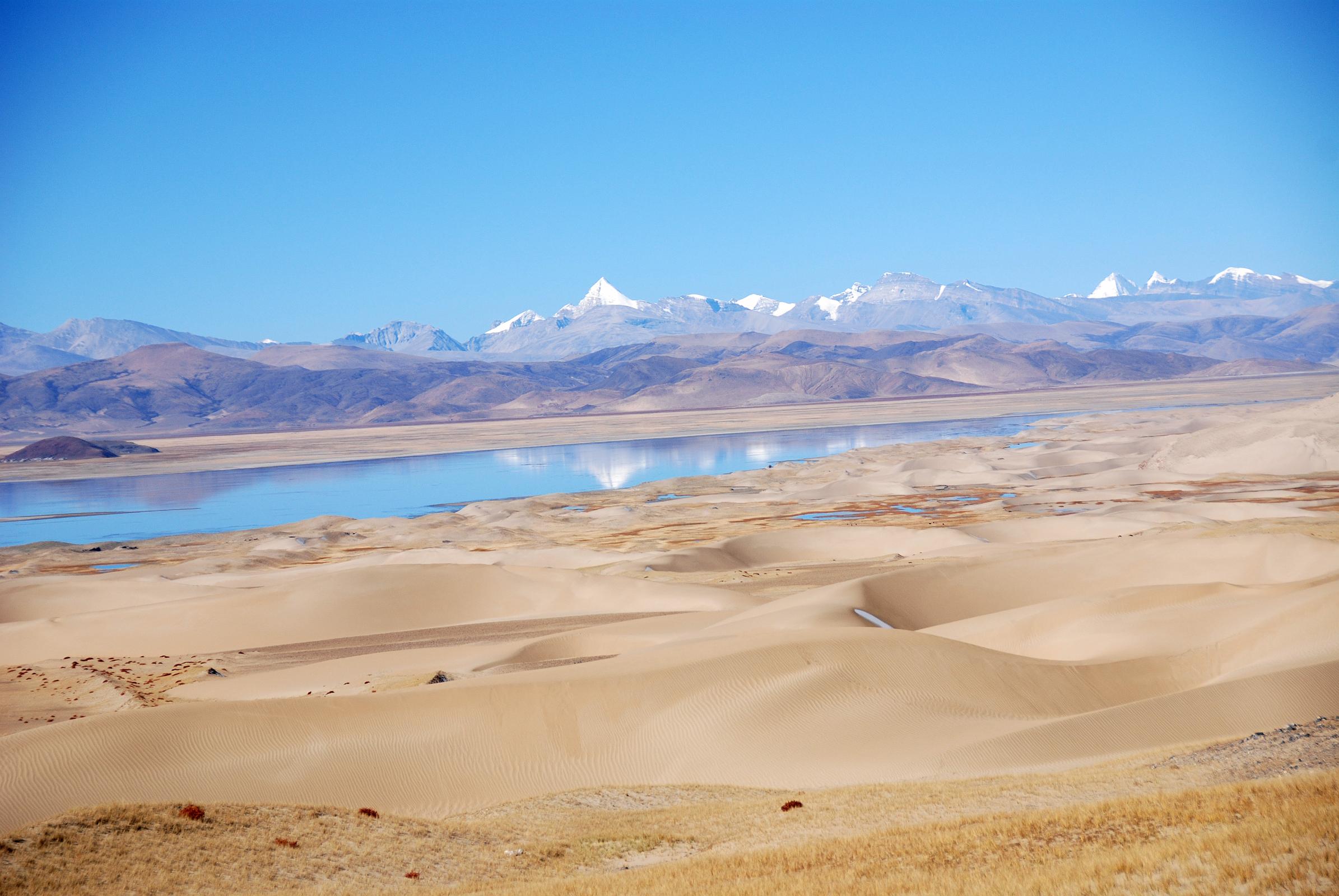 35 Sand Dunes Morning Between Old Zhongba And Paryang Tibet The mountains are reflected in the water next to the sand dunes in the morning sun on the road between Old Zhongba and Paryang Tibet.